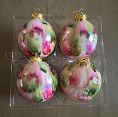 three glass christmas ornaments sitting on top of a table