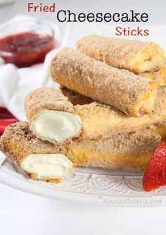 fried cheesecake sticks on a plate with strawberries