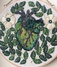 an embroidered heart surrounded by leaves and flowers