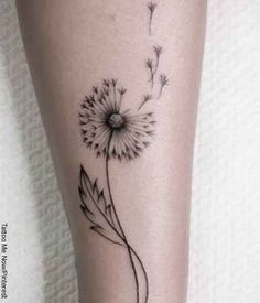 a black and white photo of a dandelion tattoo on the right leg,