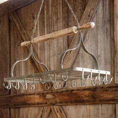 a wooden and metal chandelier hanging from a ceiling in a barn with wood paneling