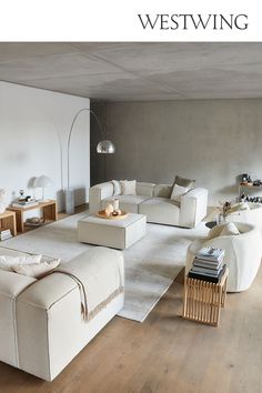 a living room filled with white furniture and wooden floors