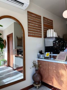 a coffee shop with mirrors and plants on the wall