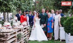 a group of people standing next to each other in front of a table with cakes on it