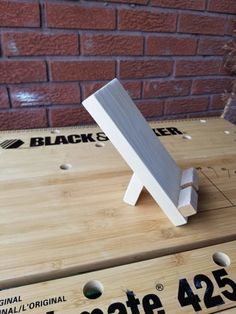 a piece of wood sitting on top of a wooden table next to a brick wall