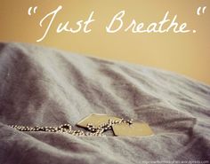 a necklace is laying on a bed with a quote above it that says, just breathe