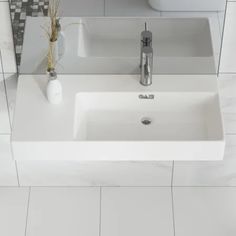 a white bathroom sink sitting under a mirror