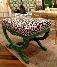 a leopard print footstool sitting on top of a rug in front of a chair