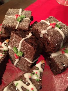 brownies with white icing and sprinkles are on a red plate