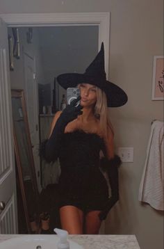 a woman in a witch costume taking a selfie