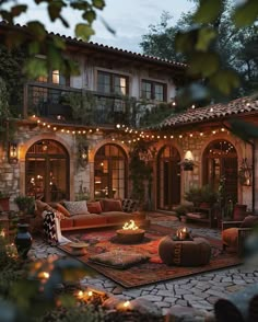 an outdoor living room is lit up with string lights