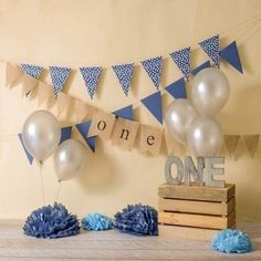 a table with balloons, cake and decorations for a one year old baby's first birthday