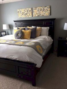 a bedroom with gray walls and yellow pillows