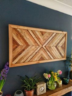 a wooden wall hanging over a mantle filled with potted plants