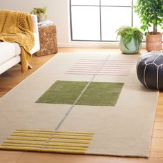 a living room area with a rug and potted plants