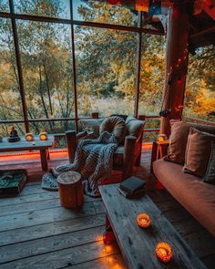 a living room filled with lots of furniture next to a large glass window covered in lights