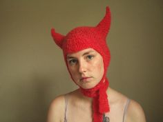 a woman wearing a red knit devil hat and scarf