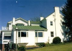 a large white house with a green roof