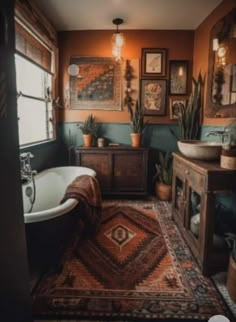 a bath room with a tub a sink and some pictures on the wall above it