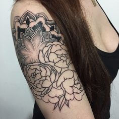 a woman's arm with flowers on it and an ornate design in the middle