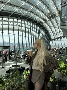 a woman with long blonde hair drinking from a cup