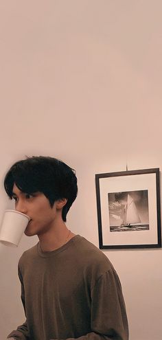 a man drinking out of a coffee cup