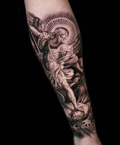 a man's arm with an angel and jesus tattoo on the left side of his arm