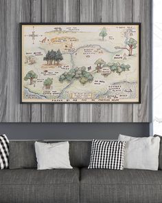 a living room with a gray couch and large map hanging on the wall above it