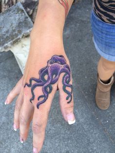 a woman's hand with an octopus tattoo on it