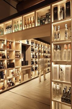 the shelves are full of bottles and liquors in different sizes, shapes and colors