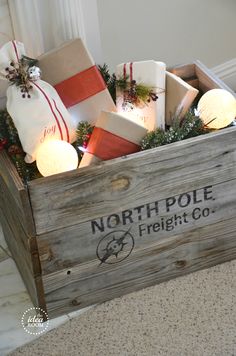 a wooden crate filled with christmas presents on top of a carpeted floor next to a wall