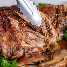 slow roasted leg of lamb on a plate with parsley garnish and seasoning