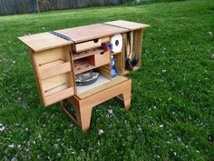 a wooden cabinet with tools in it on the grass