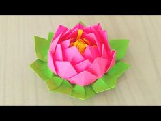 an origami lotus flower is shown in pink and green