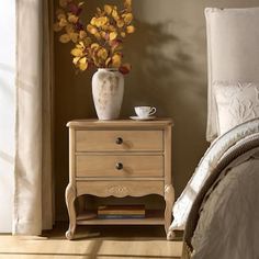 a bedroom scene with focus on the bedside table and flowers in front of the bed