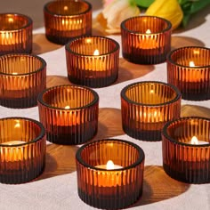 many brown glass candles sitting on top of a table