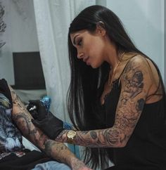 a woman with tattoos getting her arm tattooed