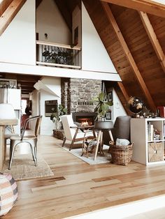 an open living room and dining area in a house with wood floors, vaulted ceiling