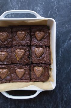 chocolate brownies in a white dish with hearts on them