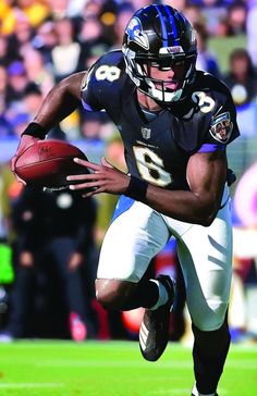 a football player running with the ball in his hand and people watching from the stands