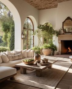 a living room filled with furniture and a fire place in the middle of an open floor plan