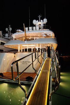 a large white boat docked at night with people on it