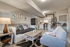 a living room filled with furniture next to a kitchen