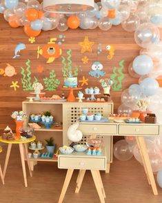 an under the sea themed birthday party with balloons, decorations and desserts on display