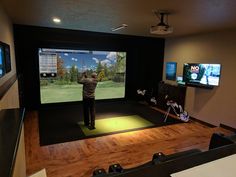 a man is playing golf on the big screen tv