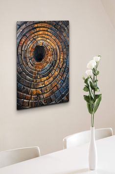 a vase filled with white flowers sitting next to a painting on a wall above a table