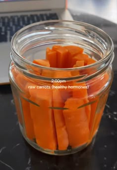 a glass jar filled with sliced carrots on top of a table