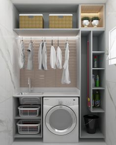 a washer and dryer in a small room with clothes hanging on the rack