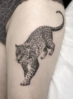 a black and white photo of a leopard on the thigh