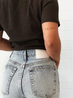 the back of a woman's jeans showing her lower body and upper half with small letters on it